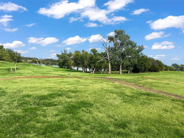 view of property's community featuring a lawn and a water view