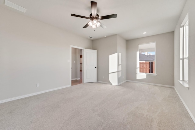 empty room featuring ceiling fan and light colored carpet