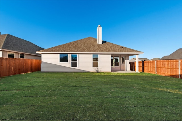 rear view of property featuring a patio and a lawn