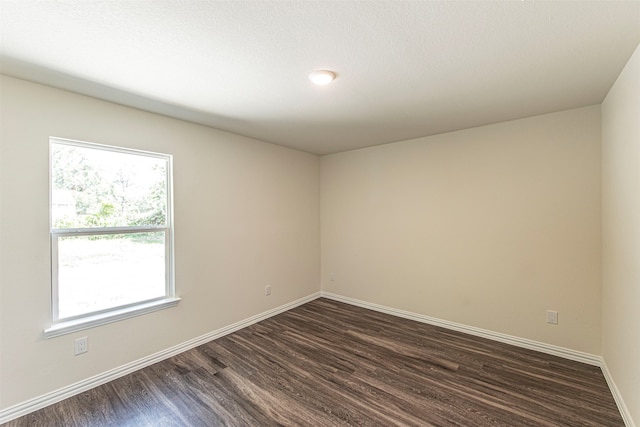 unfurnished room with a textured ceiling and dark wood-type flooring