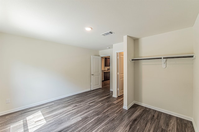 unfurnished bedroom featuring dark wood-type flooring and a closet