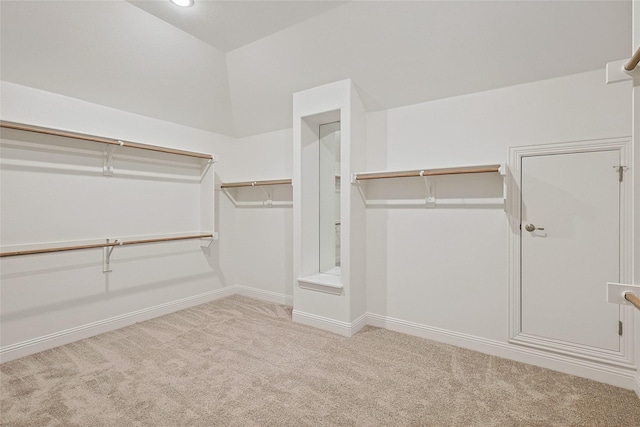 spacious closet featuring light carpet and vaulted ceiling