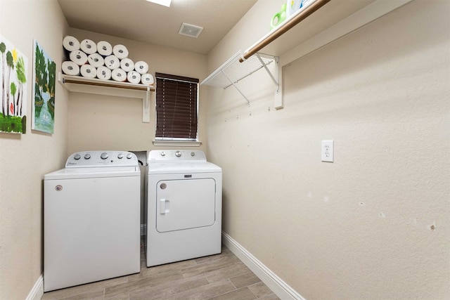 washroom featuring separate washer and dryer and light hardwood / wood-style flooring