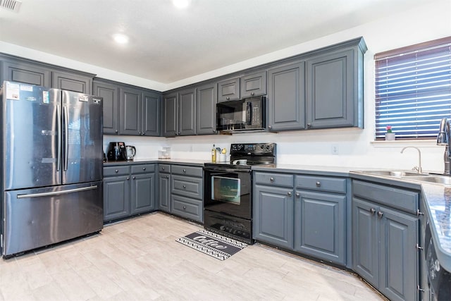 kitchen with a textured ceiling, black appliances, sink, and gray cabinets