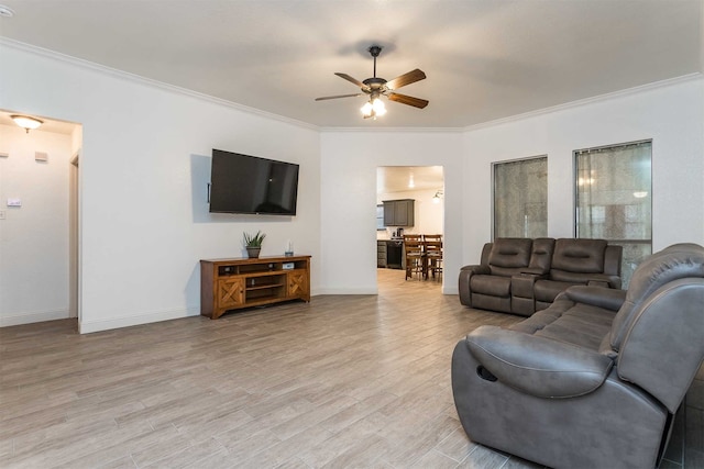 living room featuring light wood-type flooring, crown molding, and ceiling fan