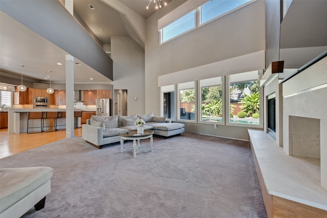 carpeted living room with a fireplace and a towering ceiling