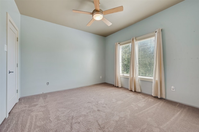 carpeted spare room featuring ceiling fan and a healthy amount of sunlight