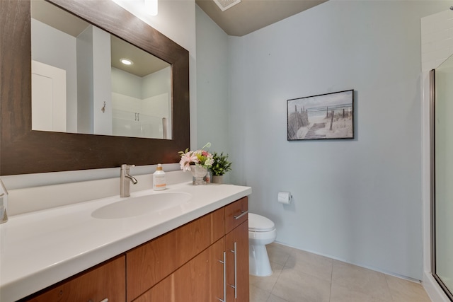 bathroom featuring tile patterned flooring, vanity, toilet, and walk in shower