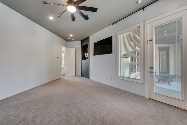 empty room with ceiling fan and light colored carpet