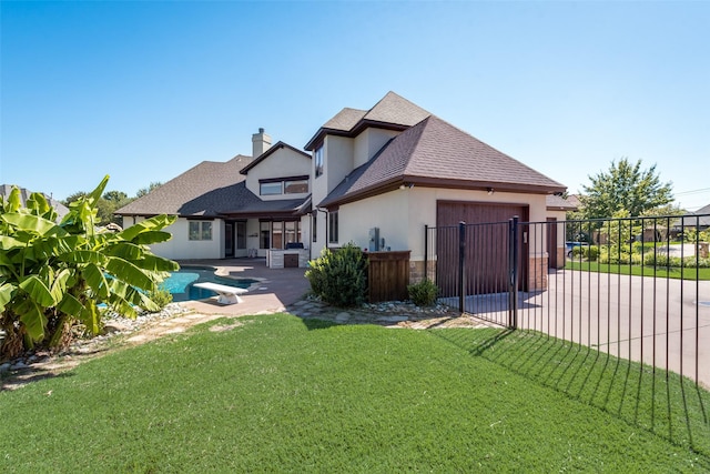 back of property with a lawn, a patio area, and a fenced in pool