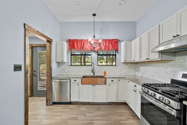 kitchen with an inviting chandelier, light hardwood / wood-style floors, stainless steel appliances, sink, and white cabinets