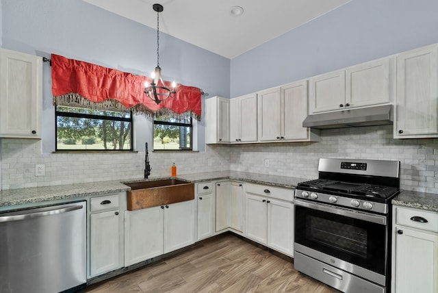 kitchen with stainless steel appliances, a notable chandelier, and white cabinets