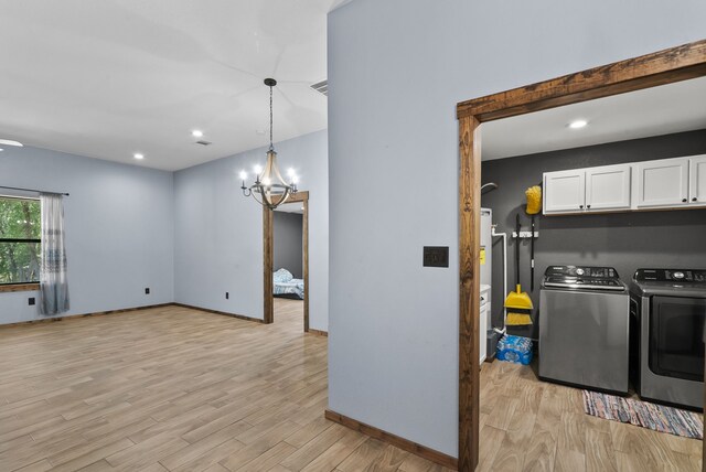 interior space featuring white cabinets, hanging light fixtures, a chandelier, light hardwood / wood-style floors, and washer and dryer