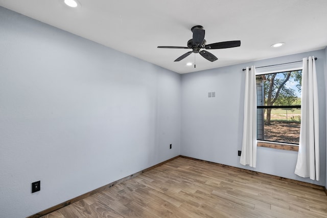 spare room with ceiling fan and light wood-type flooring