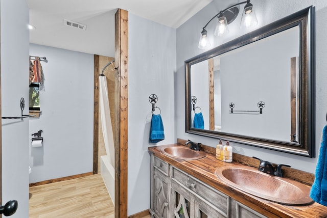 bathroom with vanity, hardwood / wood-style floors, and shower / bathtub combination with curtain