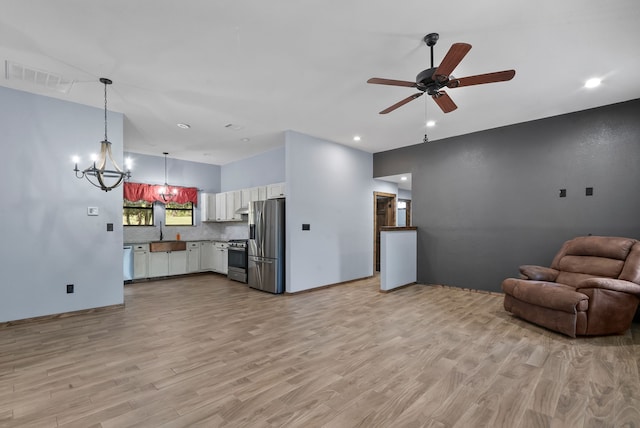 living room with ceiling fan with notable chandelier, sink, and light hardwood / wood-style floors