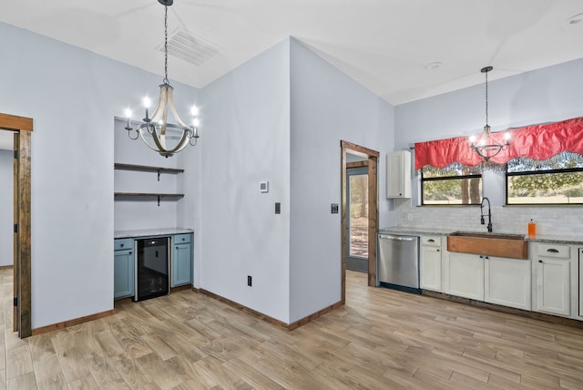 kitchen featuring dishwasher, an inviting chandelier, decorative light fixtures, and light hardwood / wood-style flooring