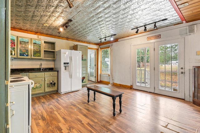 kitchen featuring wood-type flooring, green cabinets, french doors, and white appliances