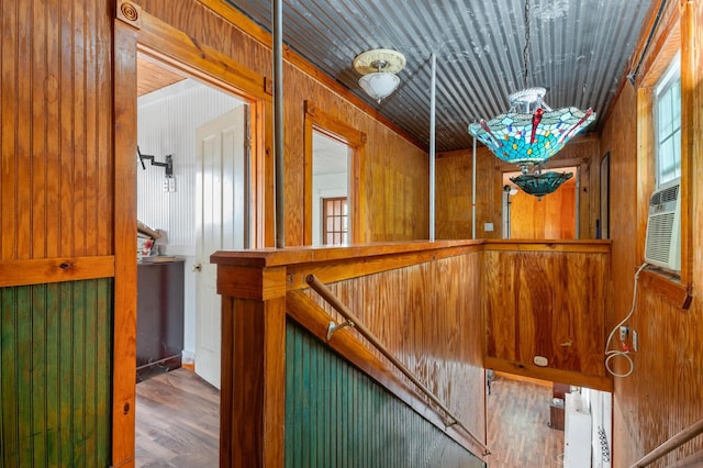 staircase with wooden walls and hardwood / wood-style flooring