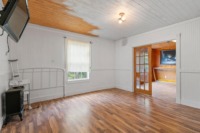 unfurnished room featuring wood-type flooring, wood ceiling, and wood walls