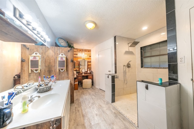 bathroom with a textured ceiling, vanity, hardwood / wood-style flooring, and walk in shower