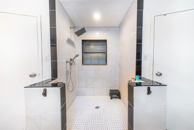 bathroom with a tile shower and a textured ceiling