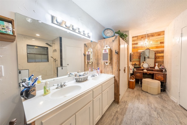 bathroom featuring a textured ceiling, vanity, wood-type flooring, and walk in shower