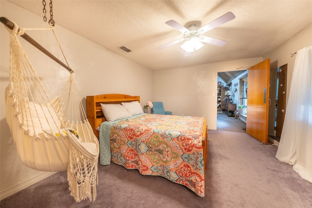 carpeted bedroom featuring ceiling fan and a textured ceiling