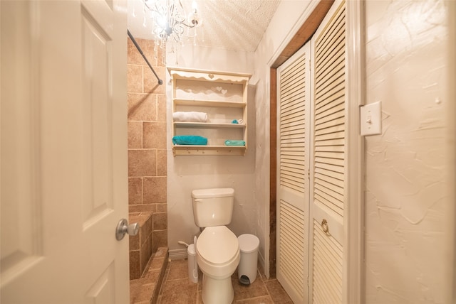 bathroom featuring tile patterned floors, toilet, and a textured ceiling