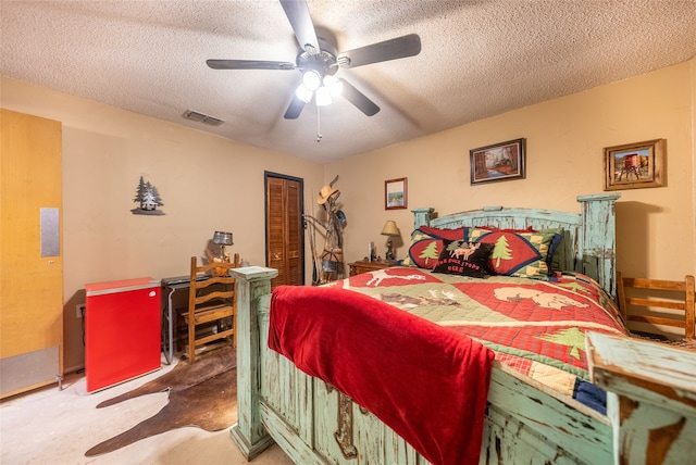 carpeted bedroom with a textured ceiling, ceiling fan, and a closet