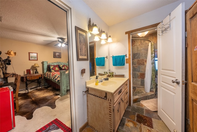 bathroom featuring a textured ceiling, vanity, a shower with curtain, and ceiling fan