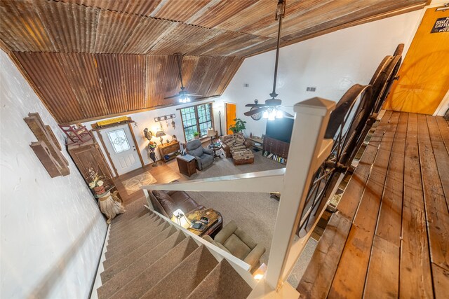 staircase with lofted ceiling, ceiling fan, hardwood / wood-style floors, and wooden ceiling