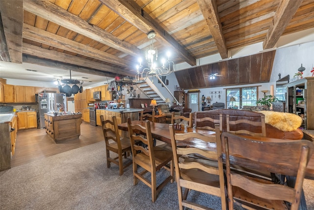 dining space with wood ceiling, light hardwood / wood-style flooring, an inviting chandelier, and beam ceiling