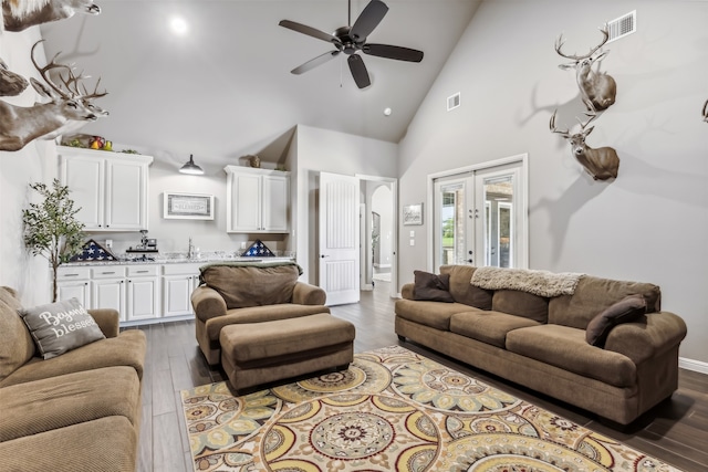 living room with ceiling fan, dark hardwood / wood-style flooring, and high vaulted ceiling