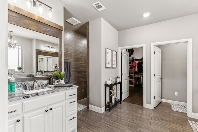 bathroom with a shower, vanity, and a chandelier