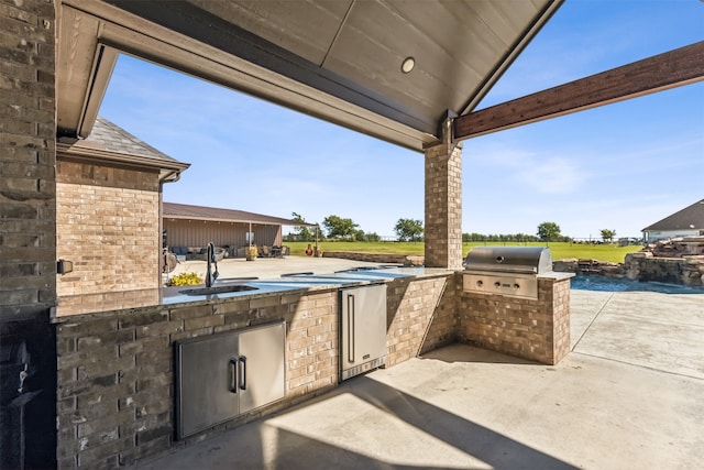 view of patio / terrace with a grill, sink, and exterior kitchen