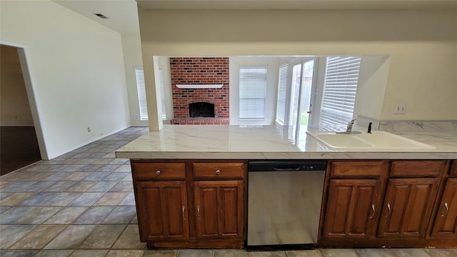 kitchen with stainless steel dishwasher, sink, and a fireplace