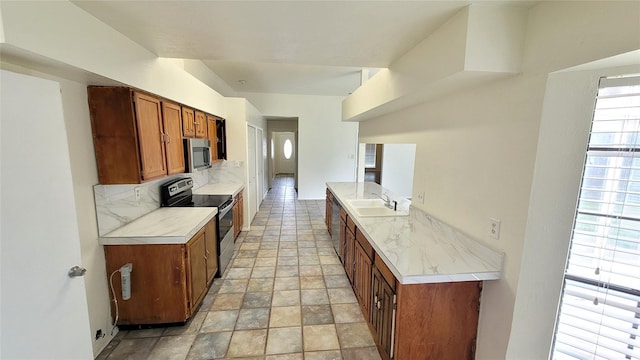 kitchen featuring sink, appliances with stainless steel finishes, and decorative backsplash