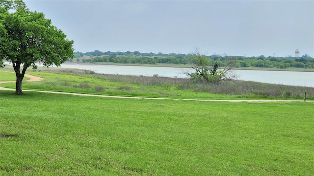 view of home's community with a water view and a yard