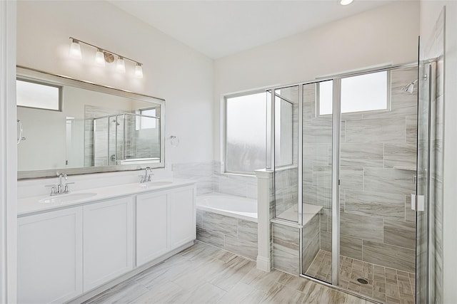 bathroom with shower with separate bathtub and vanity