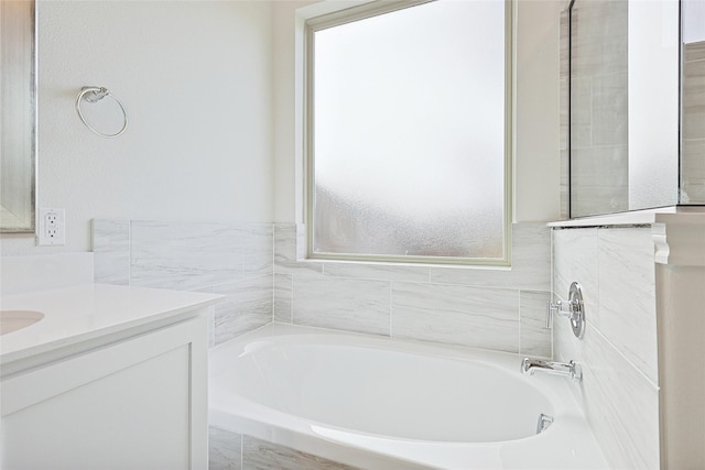 bathroom featuring tiled bath and vanity