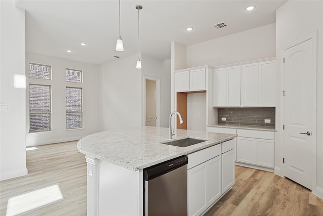 kitchen with white cabinetry, dishwasher, an island with sink, and sink