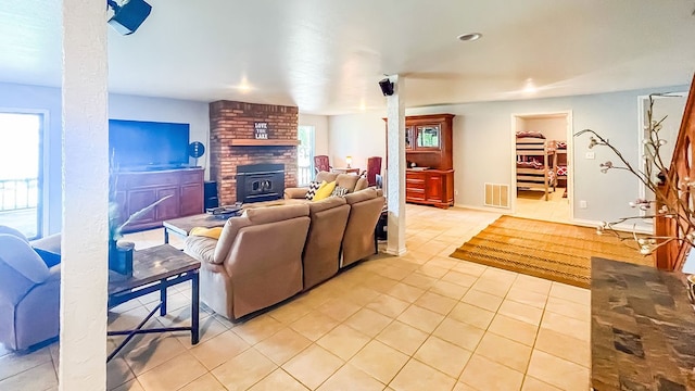 living room featuring a wood stove, light tile patterned floors, and a fireplace