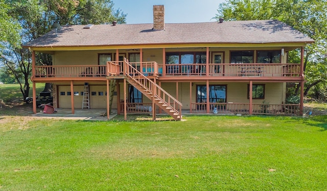 back of property featuring a yard, a wooden deck, and a patio