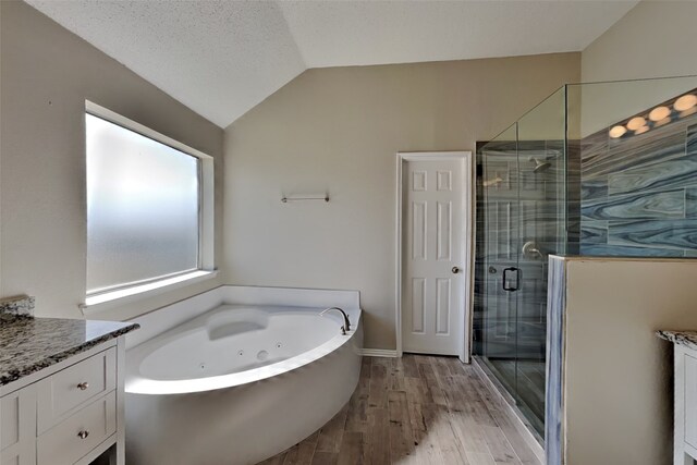 bathroom with vanity, lofted ceiling, hardwood / wood-style flooring, and separate shower and tub