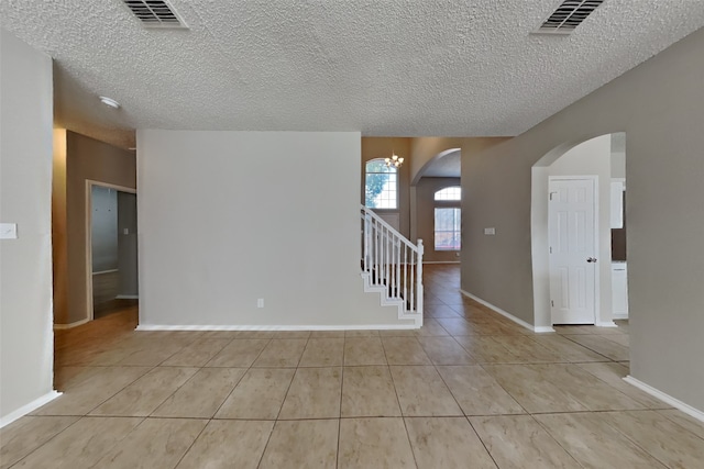 tiled spare room with a textured ceiling