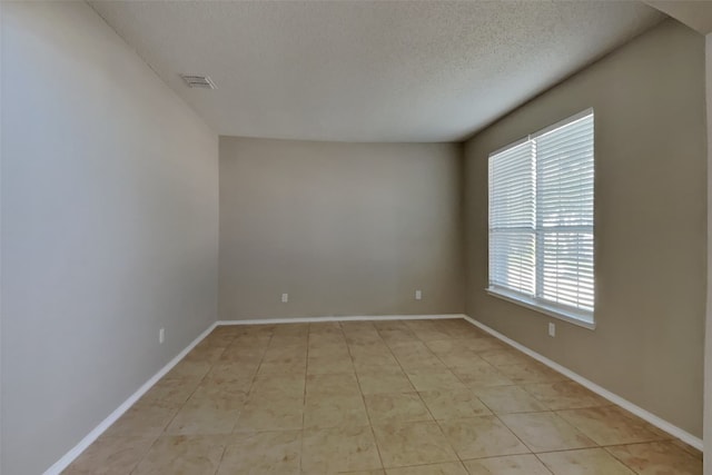 spare room with a textured ceiling