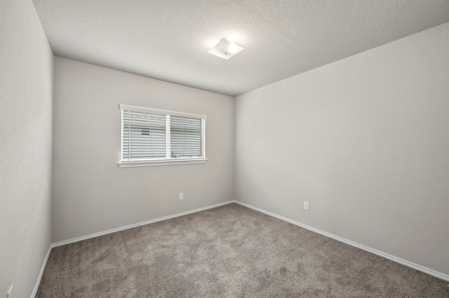 carpeted empty room with a textured ceiling