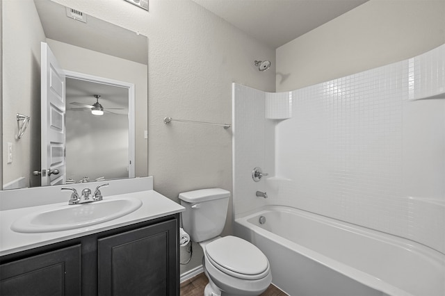 full bathroom with toilet, hardwood / wood-style floors, vanity, shower / bathtub combination, and ceiling fan