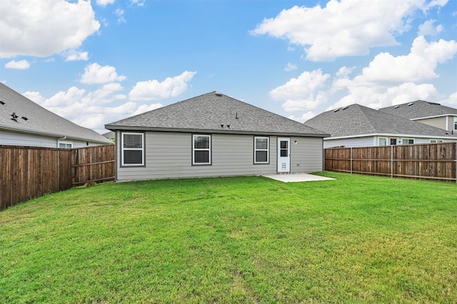 rear view of house featuring a lawn and a patio